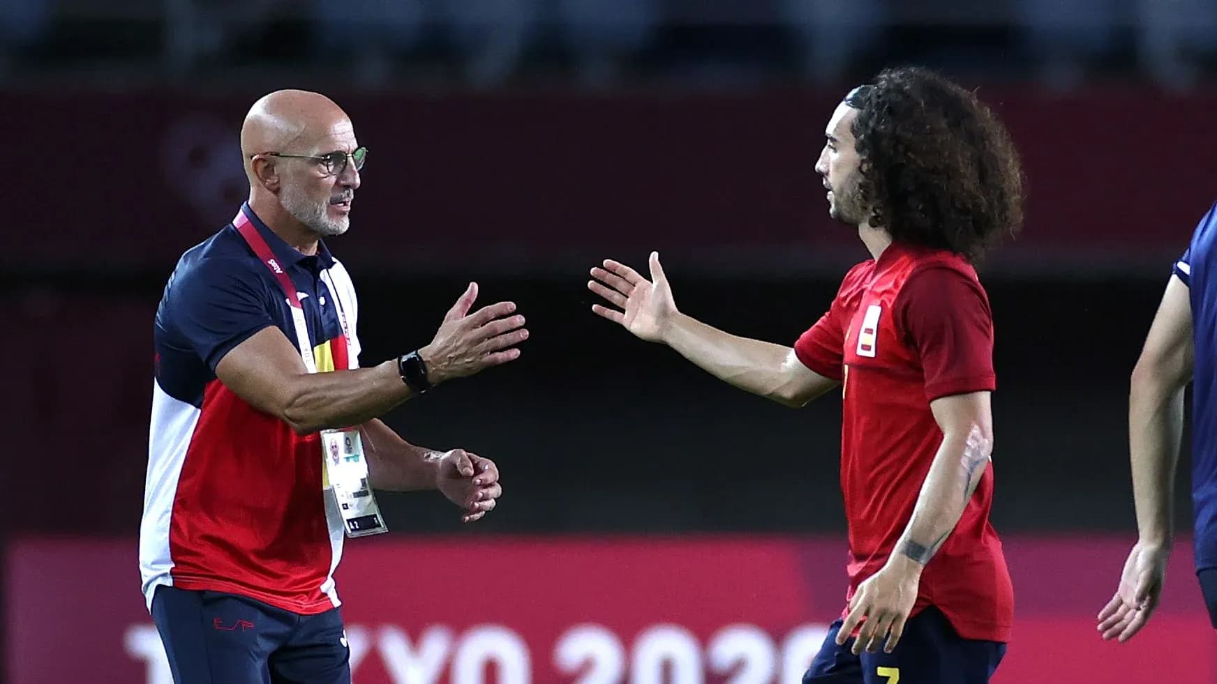 Entrenador saludando a jugador en el campo