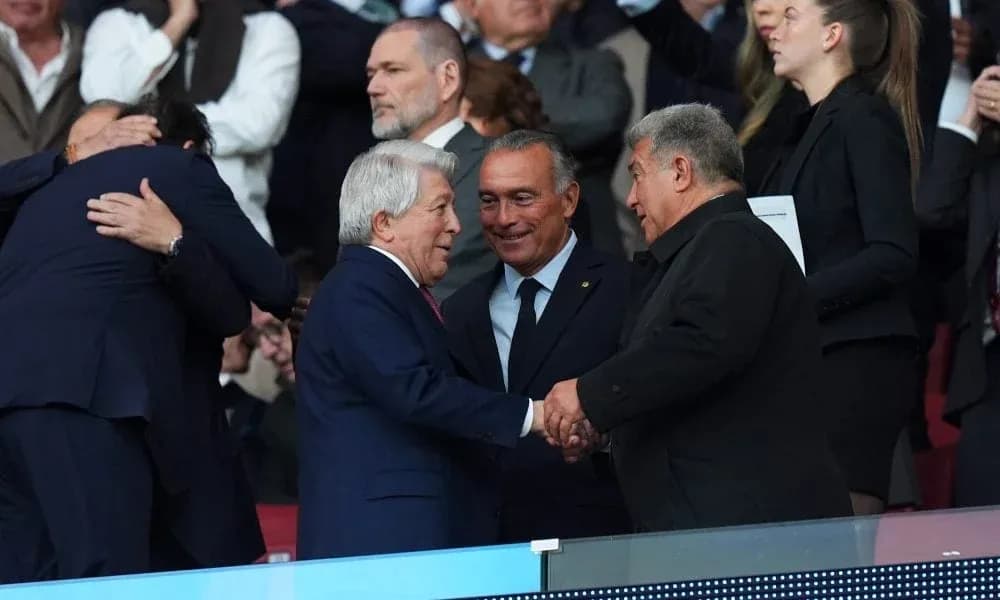 Dirigentes saludándose en el palco del estadio