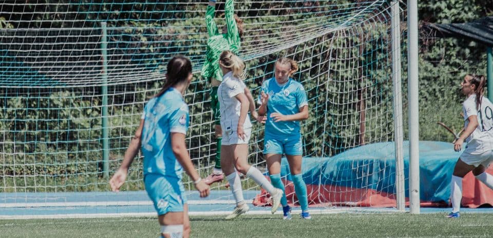 Portera atrapando el balón en el partido