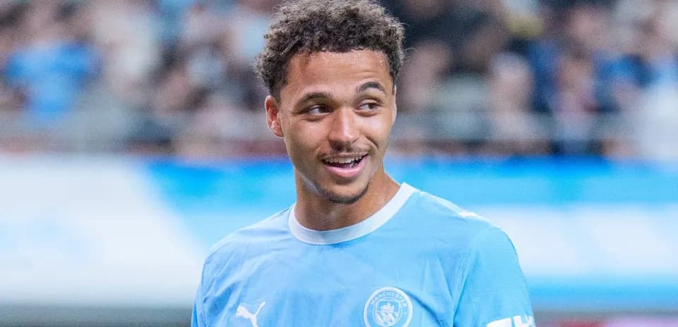 Jugador sonriendo en camiseta de Manchester City