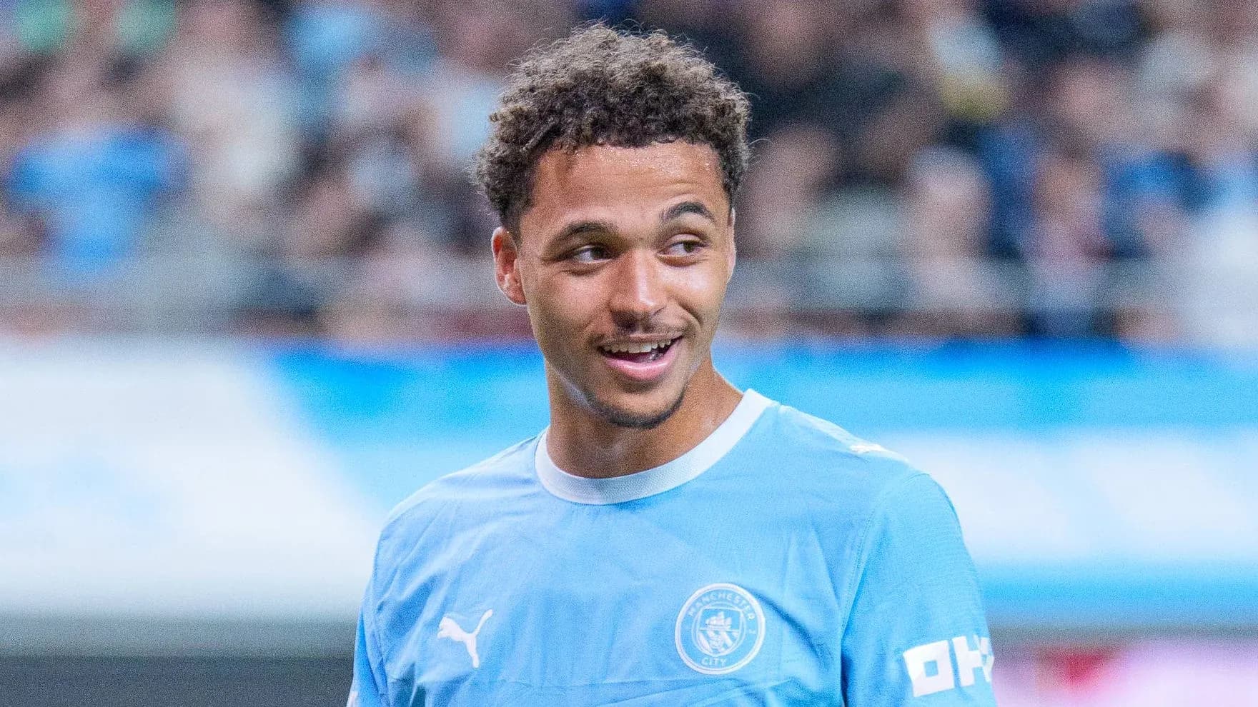 Jugador sonriendo en camiseta de Manchester City