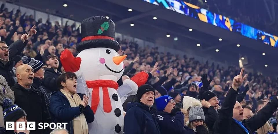 A large snowman inflatable among cheering fans