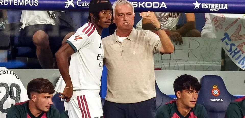 Entrenador explicando estrategia a jugador en banquillo