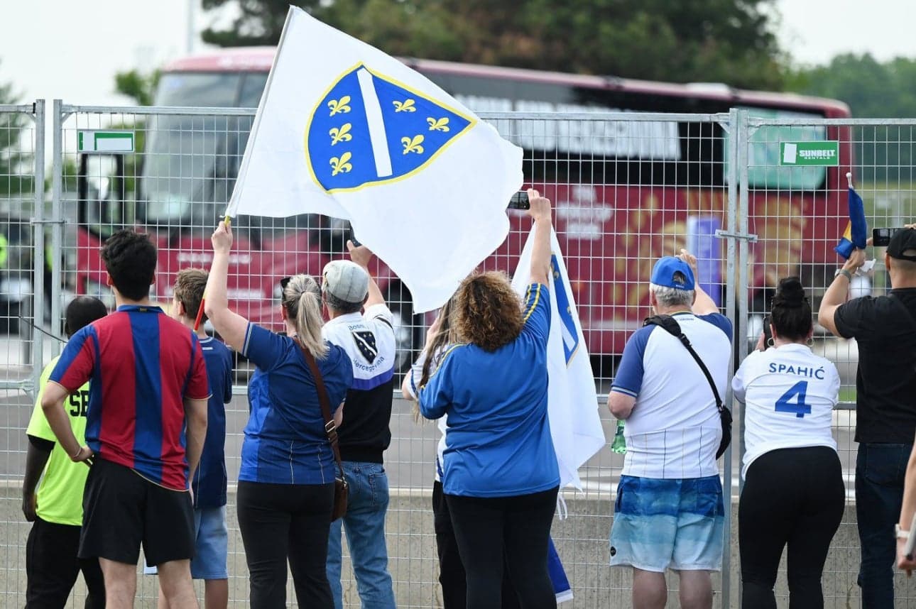 Aficionados sosteniendo banderas de Bosnia y Herzegovina