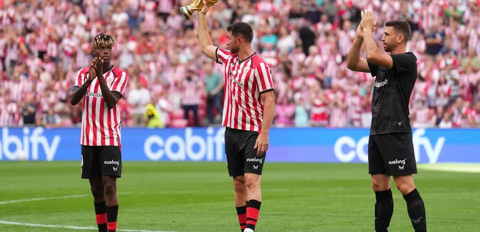 Jugadores de Athletic Club celebrando con trofeo en el campo