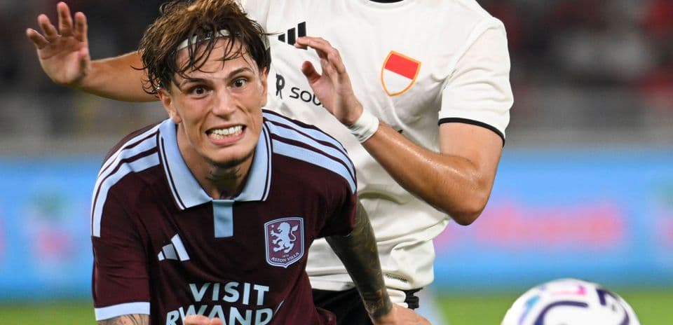 Jugador de Aston Villa siendo marcado por adversario