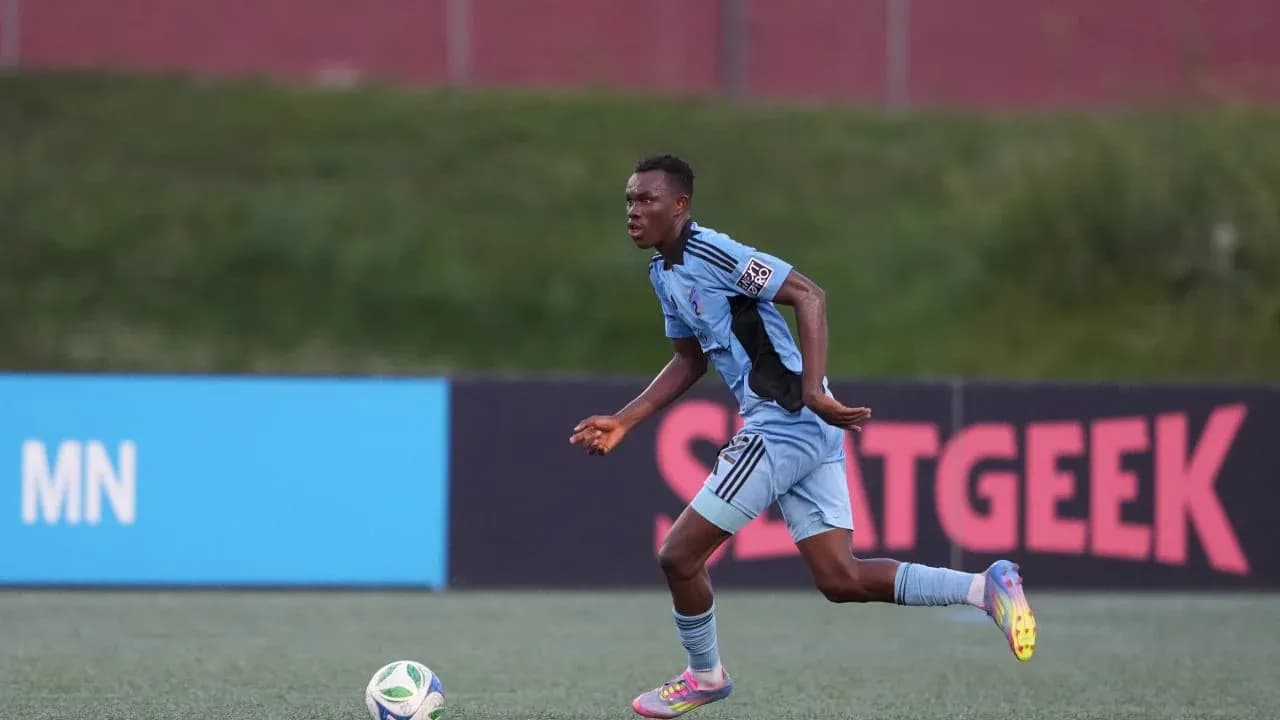 Jugador corriendo con el balón en el campo