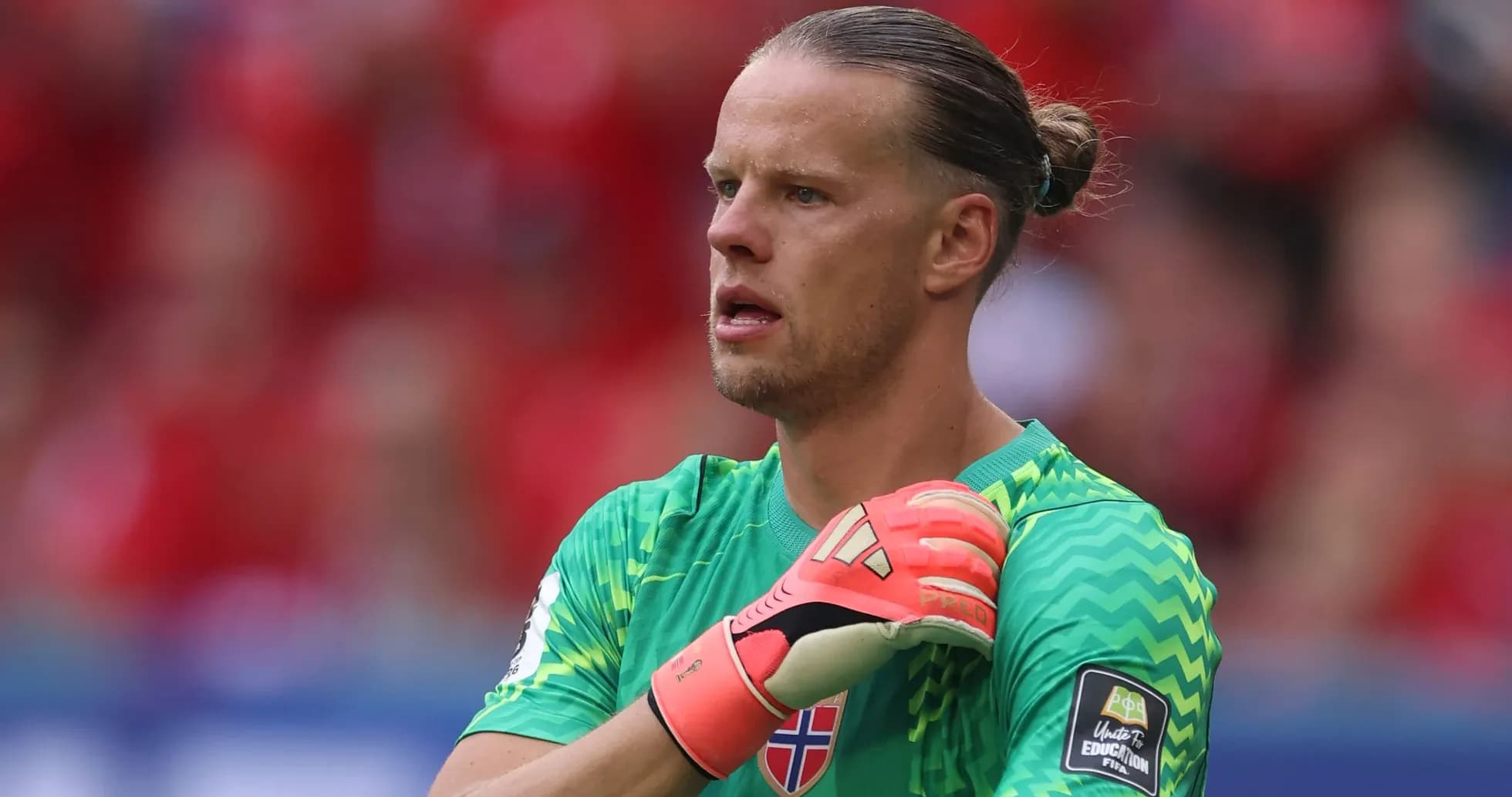 Portero noruego ajustándose los guantes en el partido