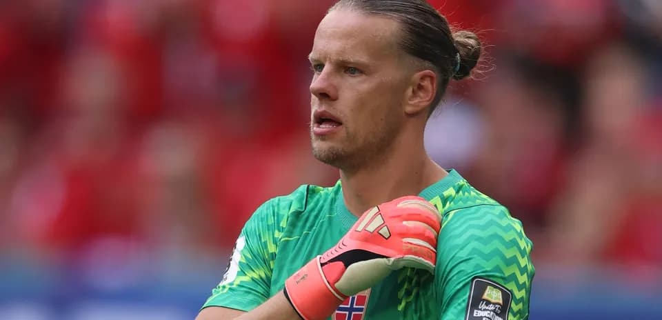 Portero noruego ajustándose los guantes en el partido