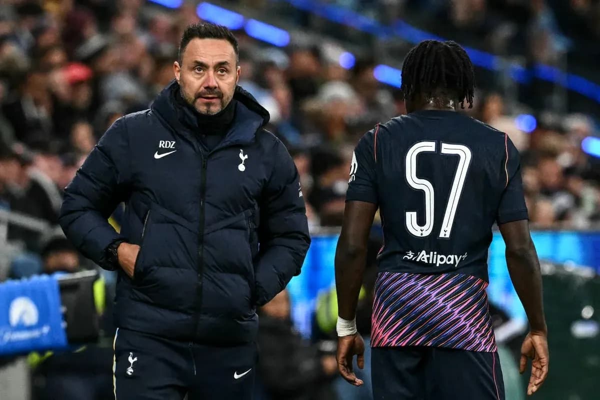 Entrenador de Tottenham hablando con jugador en el banquillo