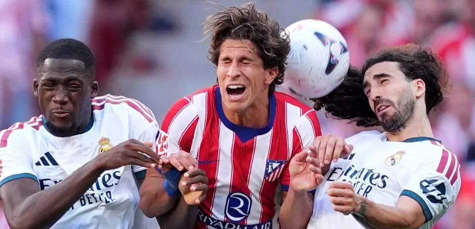 Jugadores de Atlético de Madrid y Real Madrid disputando el balón