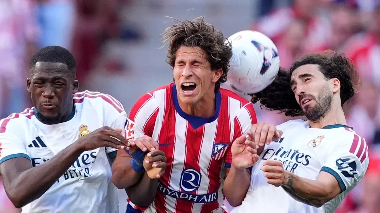Jugadores de Atlético de Madrid y Real Madrid disputando el balón