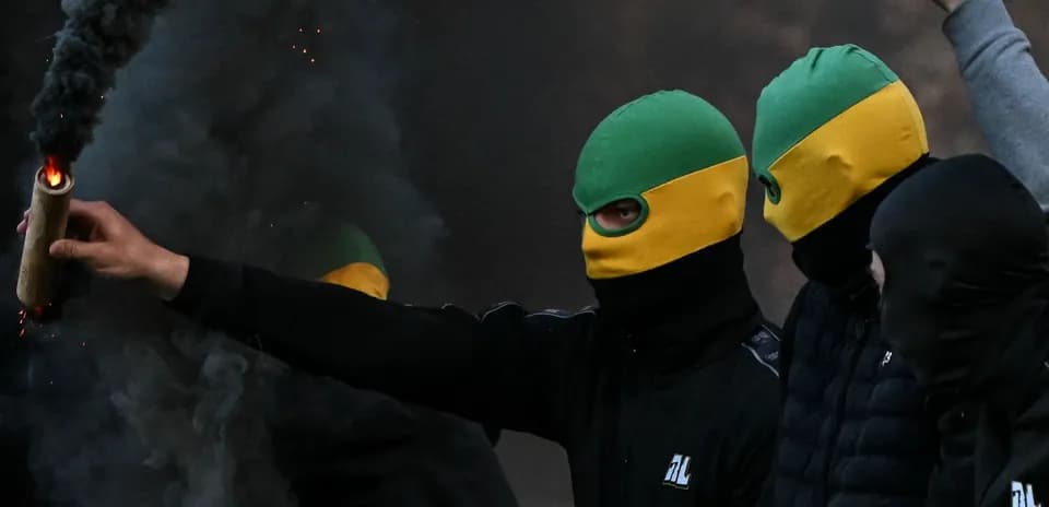 Grupo de personas con máscaras encendiendo un artefacto