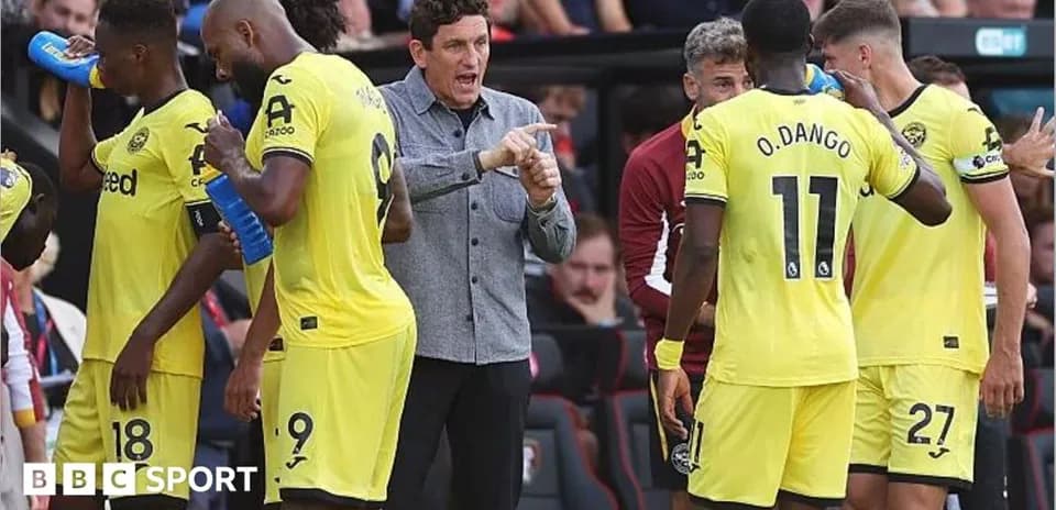 Entrenador hablando con jugadores en la banda