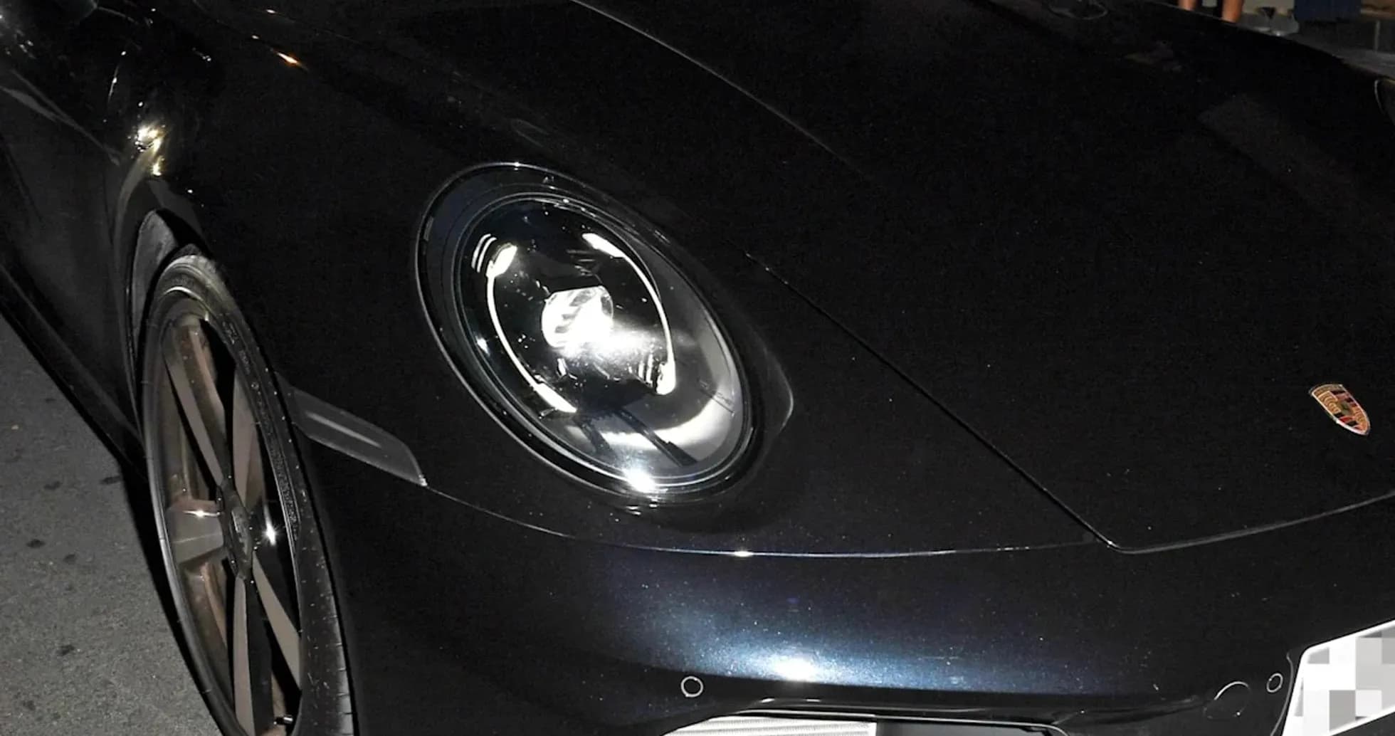 Dos personas sentadas en un Porsche negro