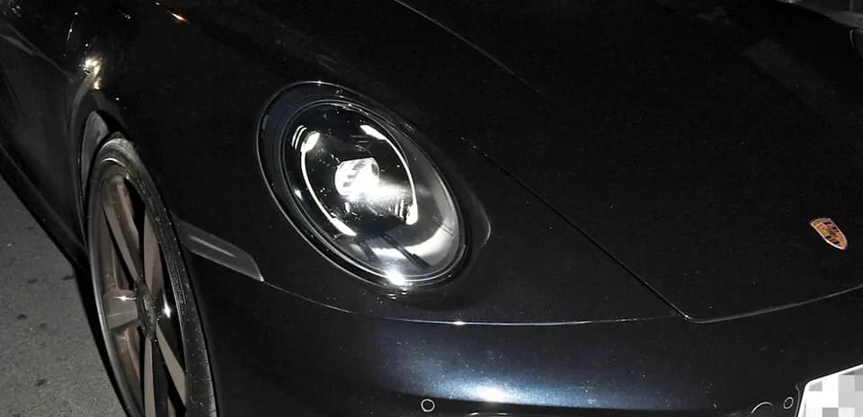 Dos personas sentadas en un Porsche negro