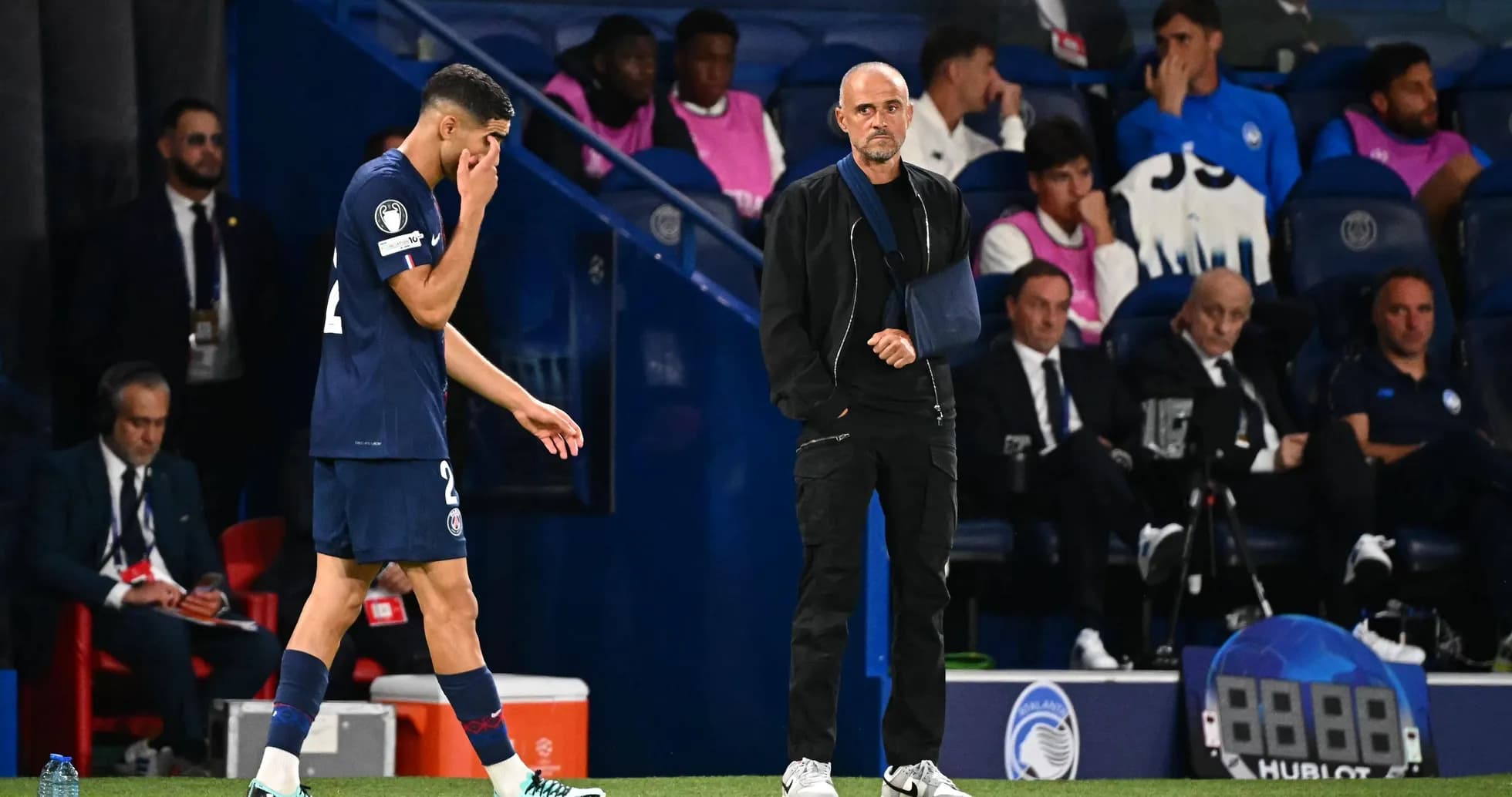 Jugador saliendo del campo con entrenador observando
