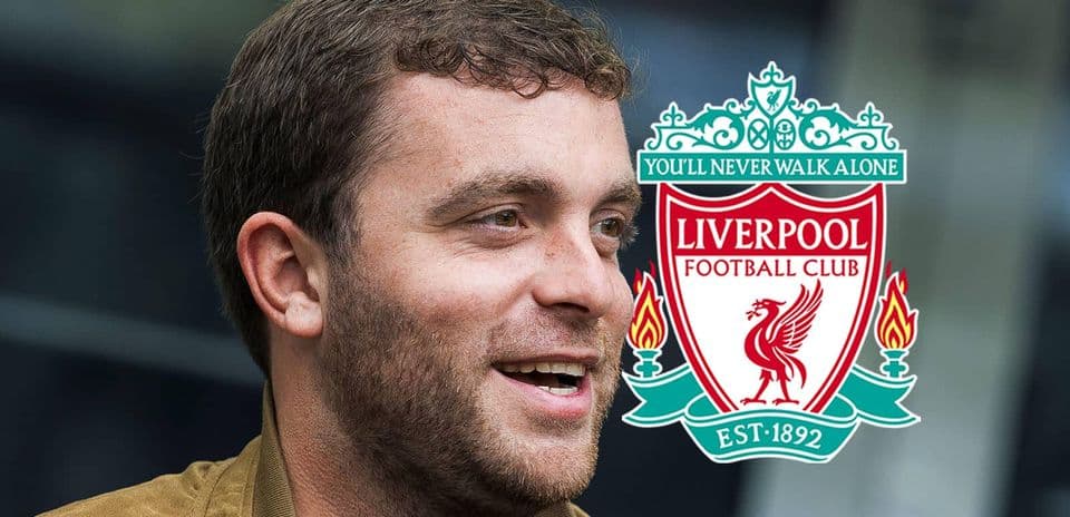 Persona sonriendo con escudo de Liverpool detrás