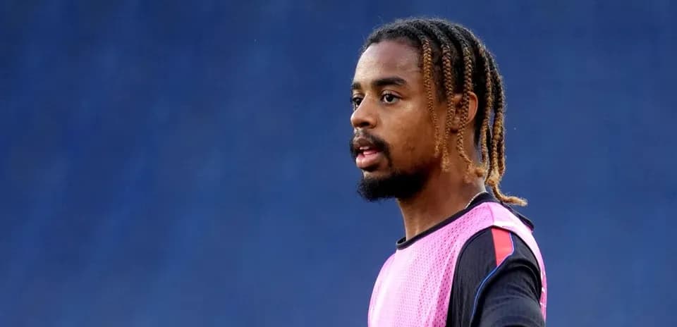 Jugador en calentamiento con camiseta rosa en campo