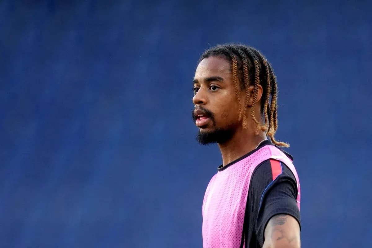 Jugador en calentamiento con camiseta rosa en campo
