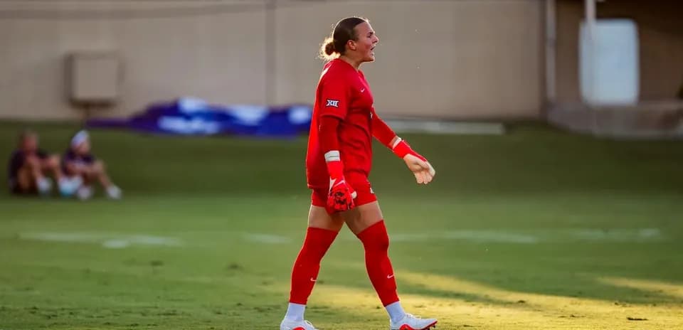 Portera en uniforme rojo durante partido de fútbol