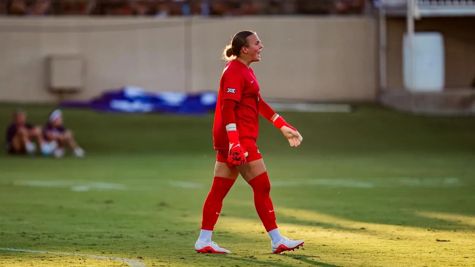 Portera en uniforme rojo durante partido de fútbol
