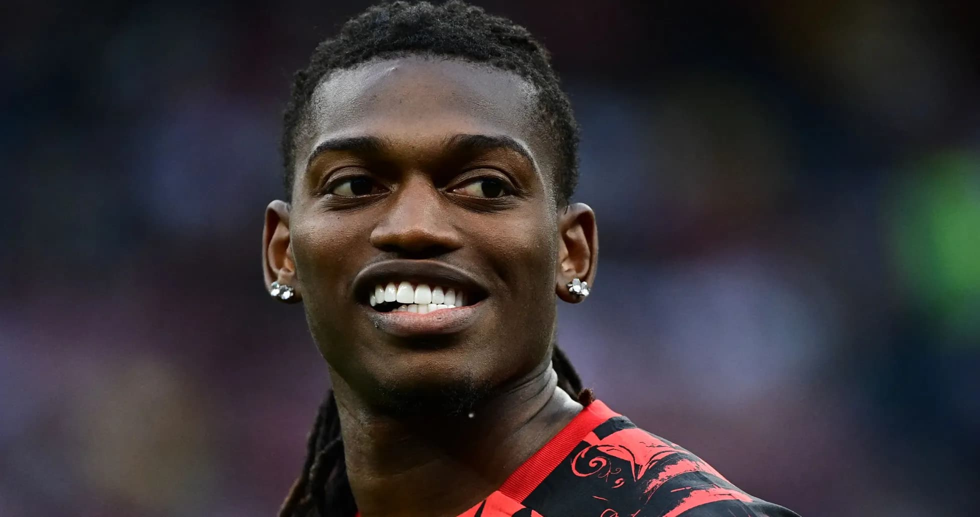 Jugador sonriendo en uniforme rojo durante el partido