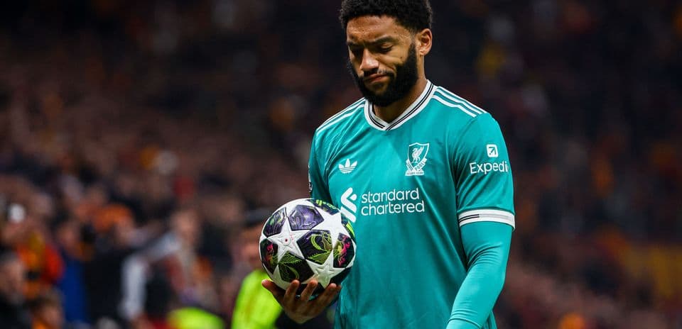 Jugador sosteniendo un balón en el campo de fútbol