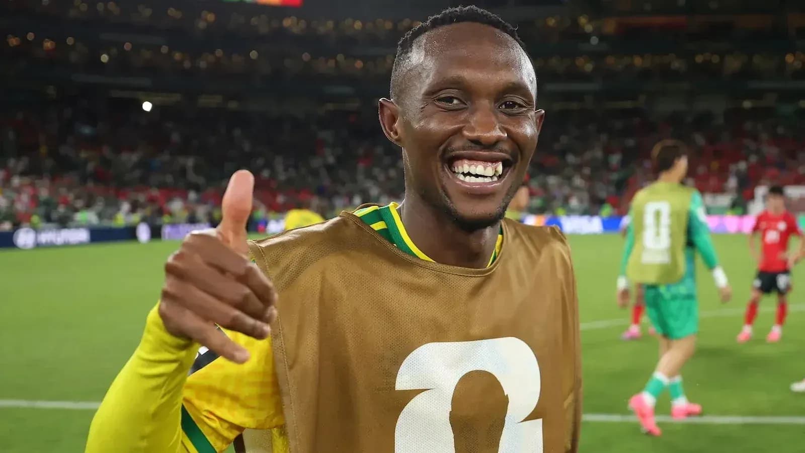 Jugador sonriendo y haciendo pulgar hacia arriba en el campo