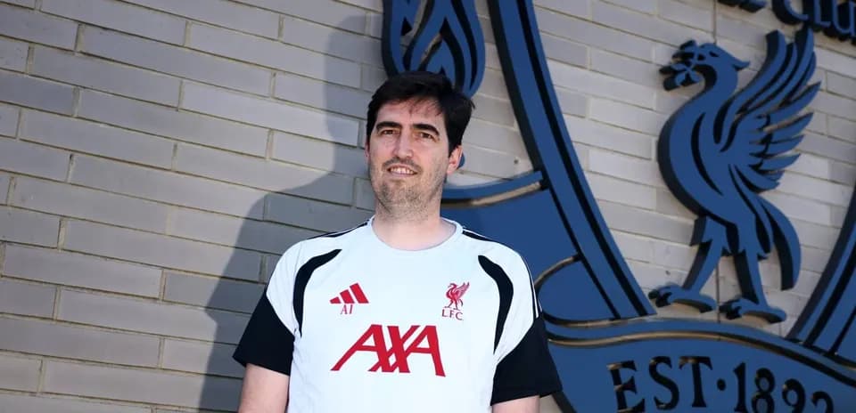 Entrenador posando frente al logo del Liverpool