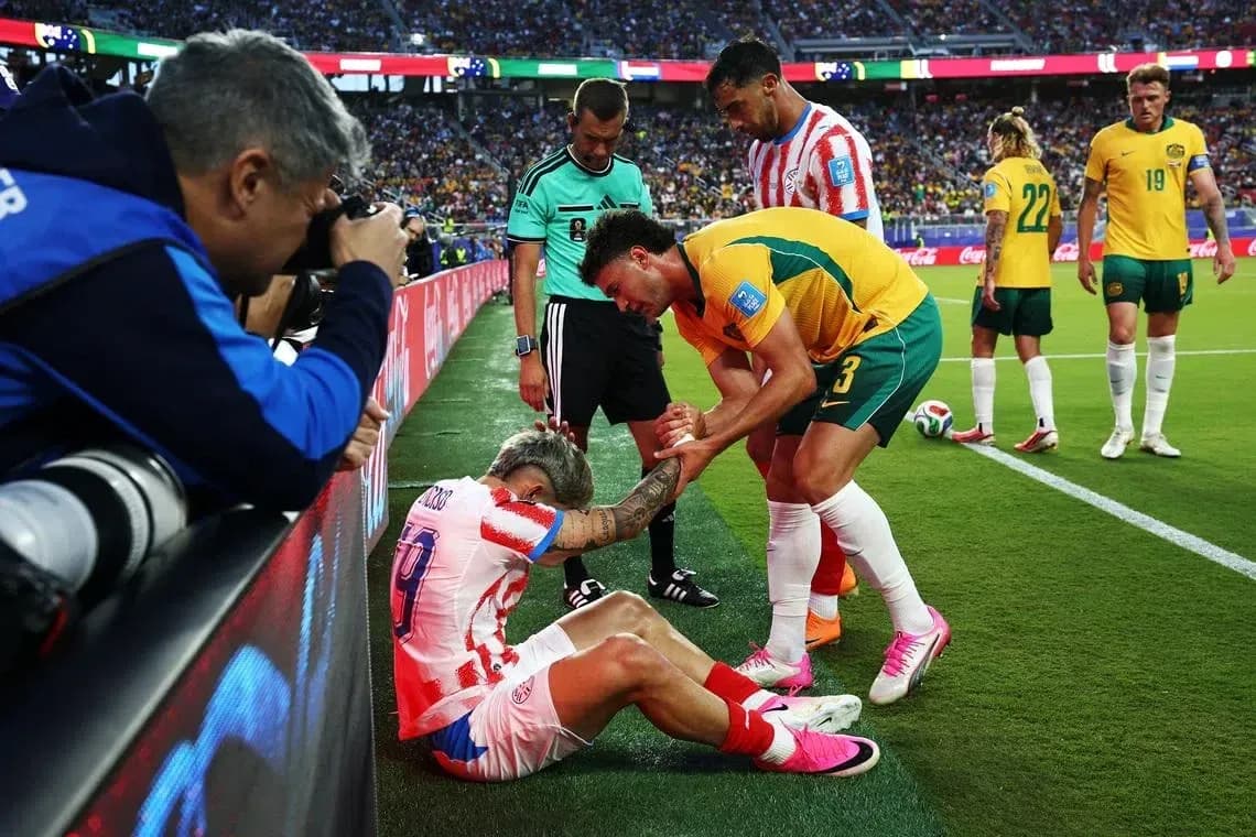 Jugador caído siendo ayudado por adversarios en el campo