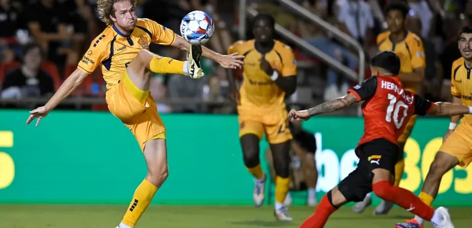 Jugador de fútbol despejando el balón en el partido