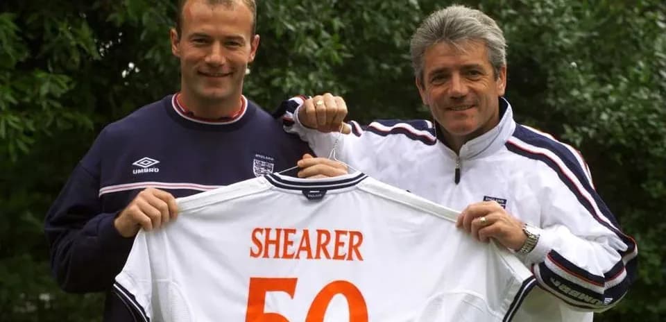 Alan Shearer y entrenador sosteniendo camiseta de Inglaterra