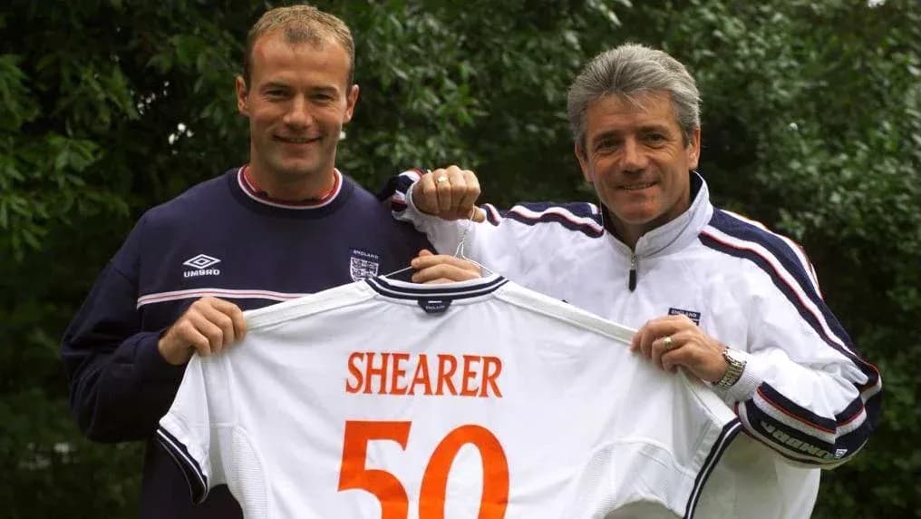 Alan Shearer y entrenador sosteniendo camiseta de Inglaterra