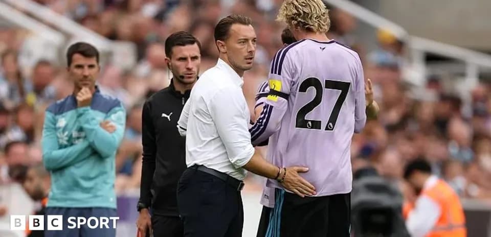 Entrenador hablando con portero en la banda