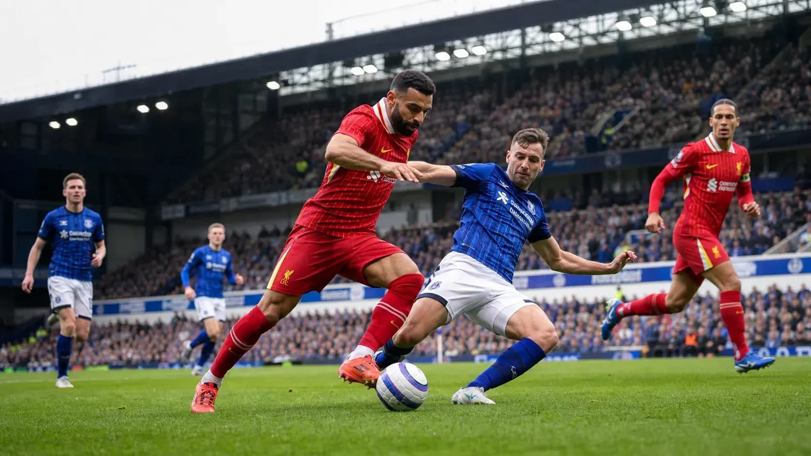 Jugadores disputando el balón en partido Liverpool-Everton