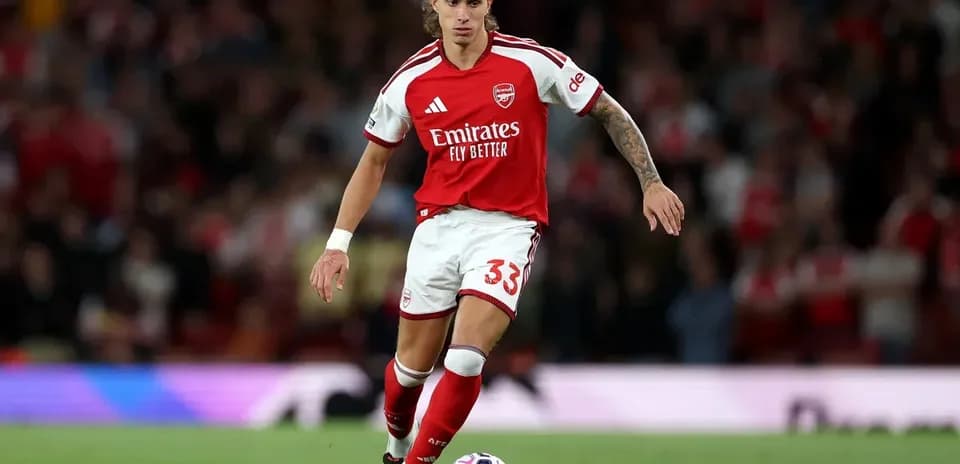 Jugador de Arsenal avanzando con el balón en el campo