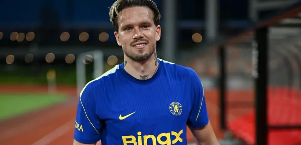 Jugador de fútbol con camiseta de Chelsea sonriendo