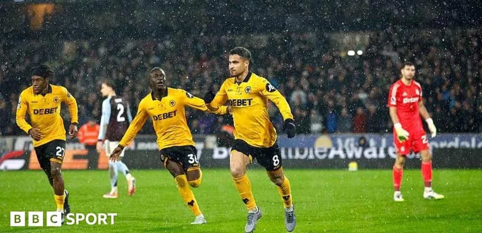 Jugadores de Wolves celebrando un gol en partido lluvioso