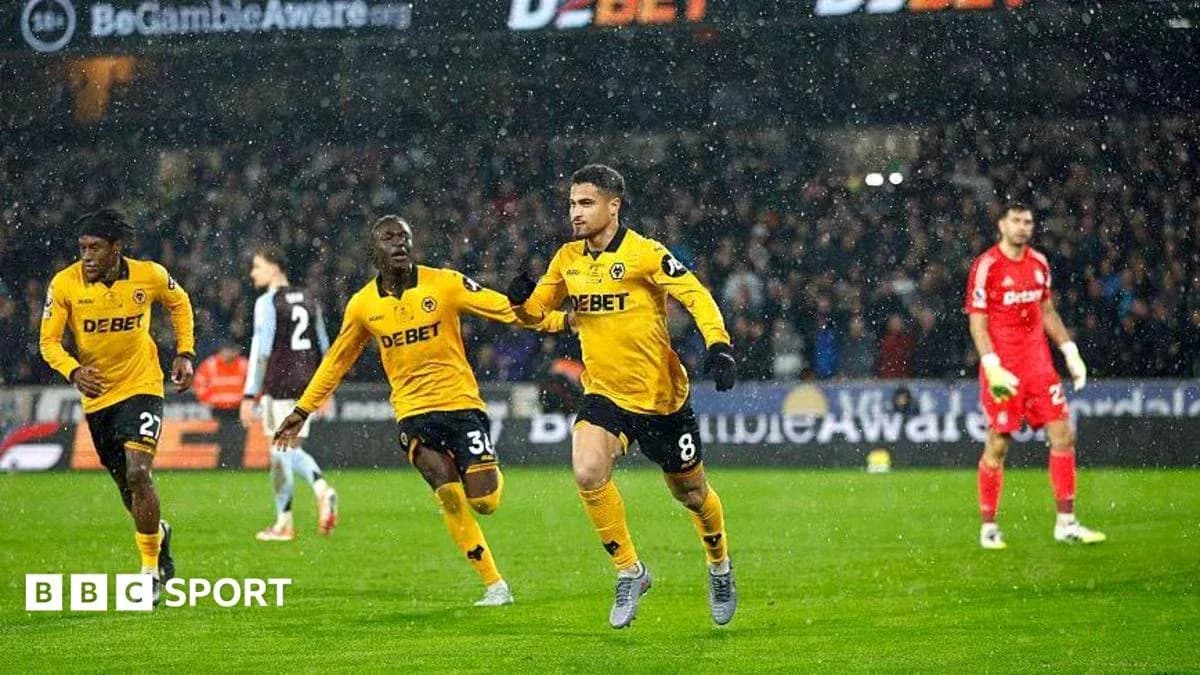Jugadores de Wolves celebrando un gol en partido lluvioso