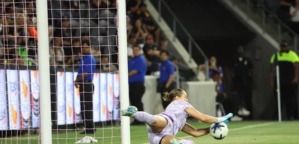 Portera atrapando el balón en el partido
