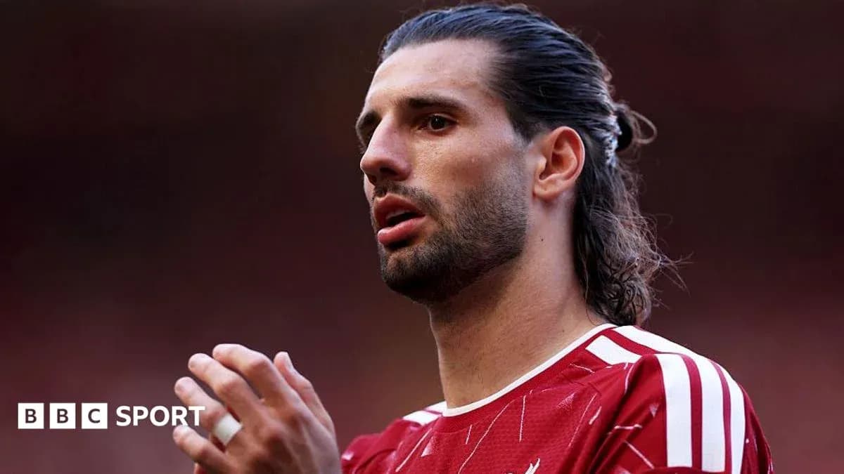 Jugador de fútbol en camiseta roja hablando en el campo
