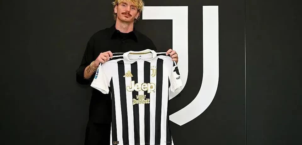 Jugador mostrando camiseta de Juventus en presentación