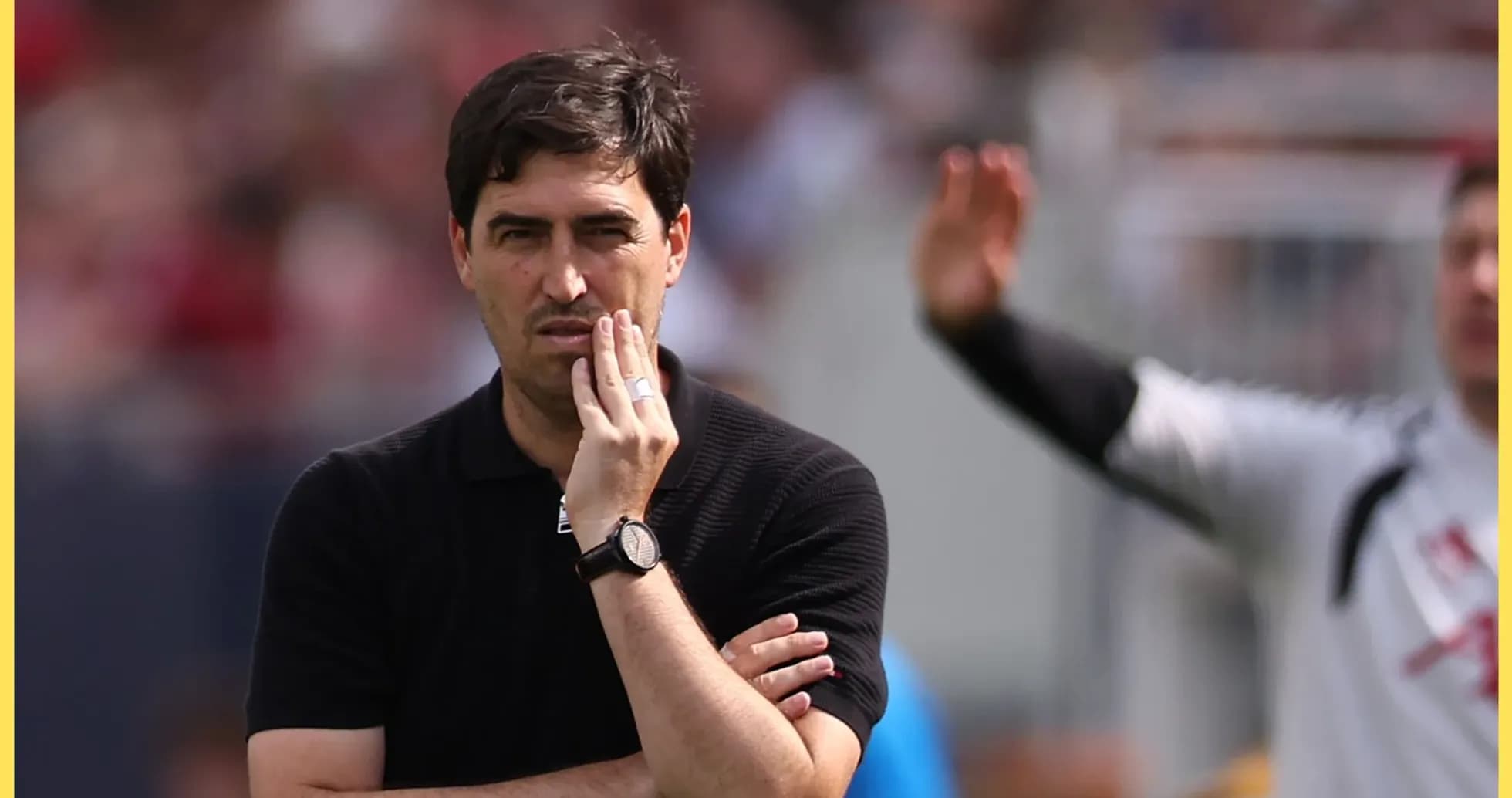 Entrenador observando el partido con expresión pensativa
