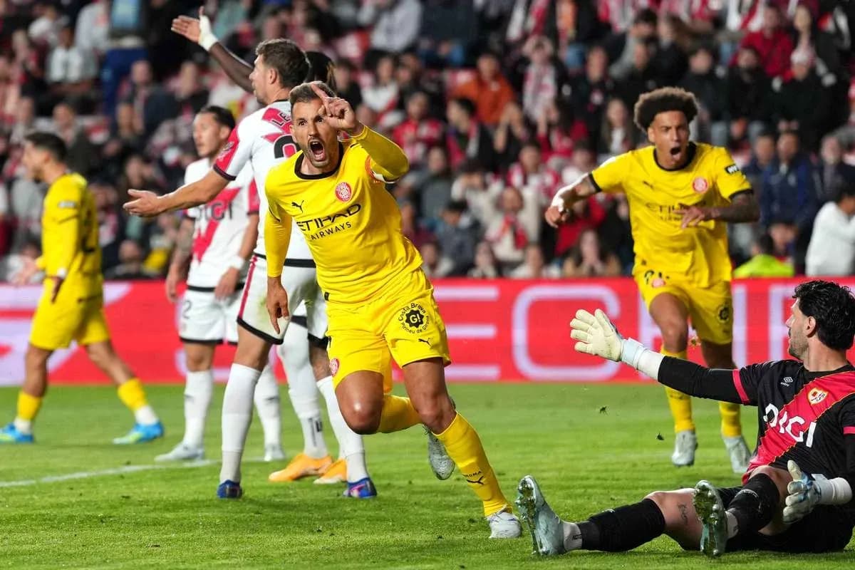 Jugador celebrando gol mientras el portero observa