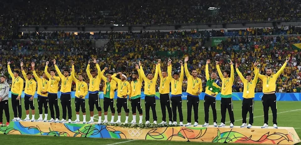 Equipo de fútbol brasileño celebrando medallas en el podio