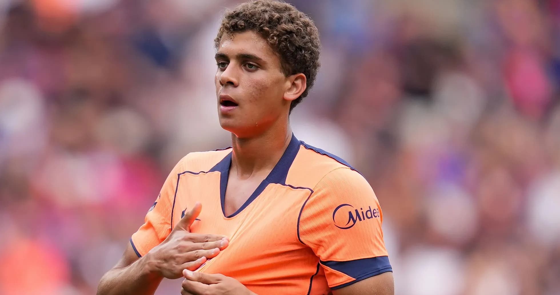 Jugador en uniforme naranja preparándose para el partido