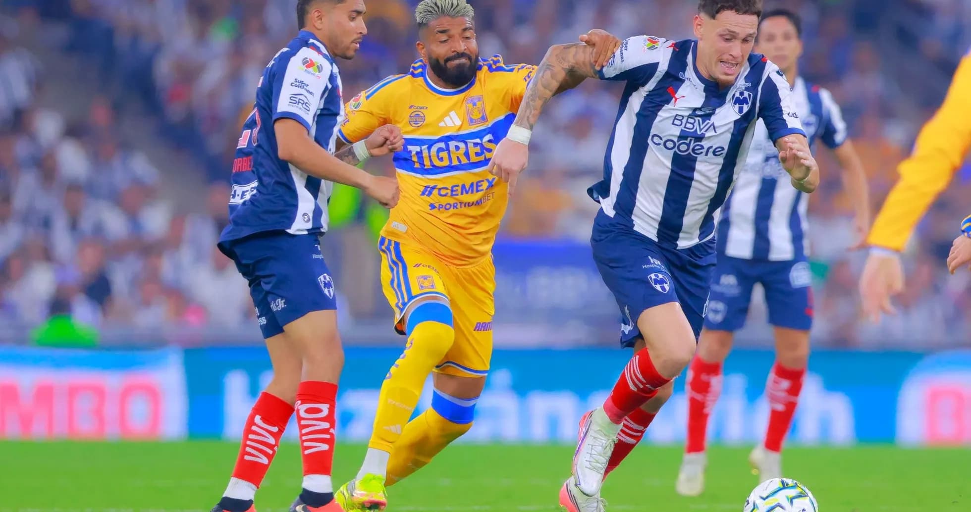 Jugadores de Monterrey y Tigres compiten por el balón