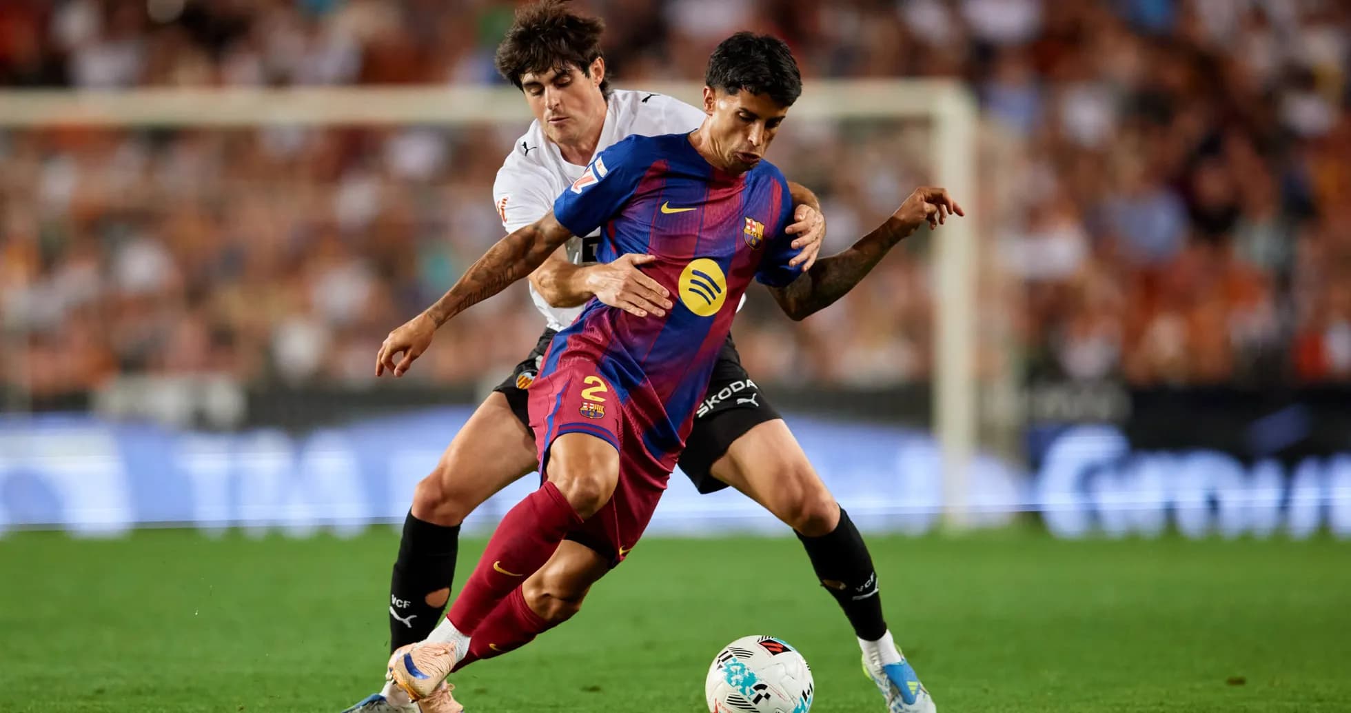 Jugador de Barcelona siendo marcado por rival
