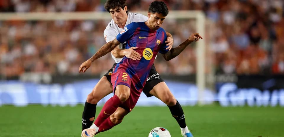 Jugador de Barcelona siendo marcado por rival